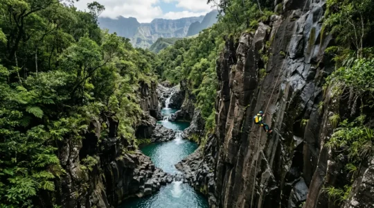 Descente en rappel dans un canyon de basalte noir avec cascade turquoise à La Réunion