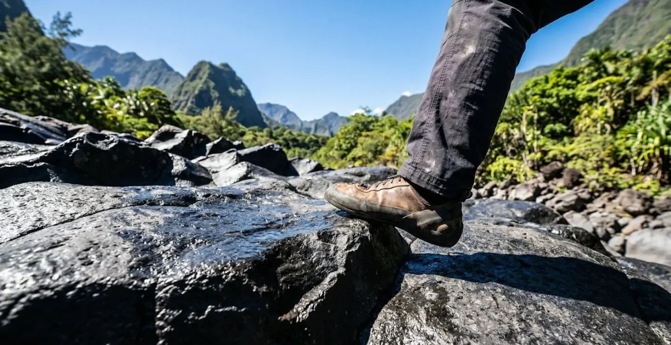 Grimpeur posant précisément son pied sur une paroi de basalte noir caractéristique de la Réunion