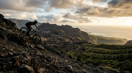 VTTiste expert négociant une descente technique sur terrain volcanique avec vue sur l'océan