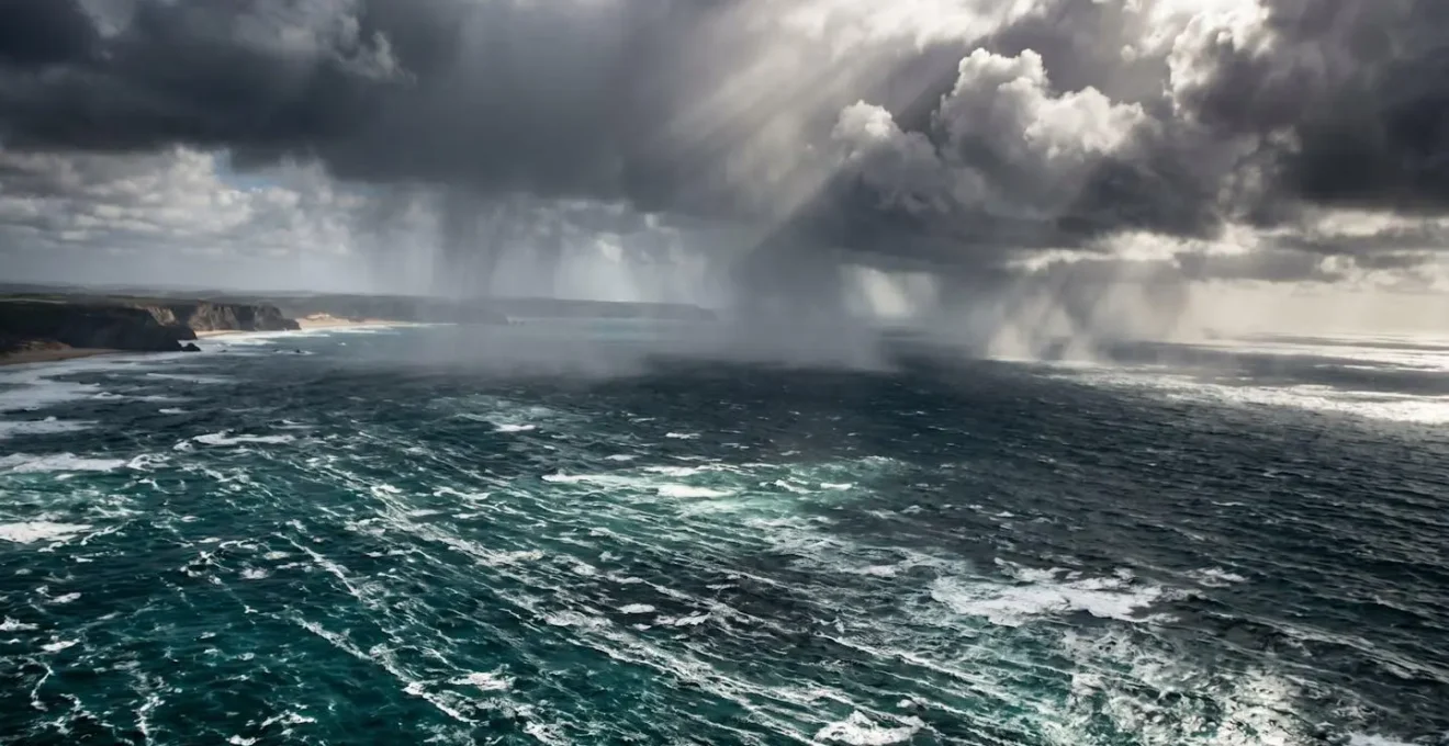 Vue aérienne de la côte ouest de La Réunion avec cellules orageuses visibles et mer agitée